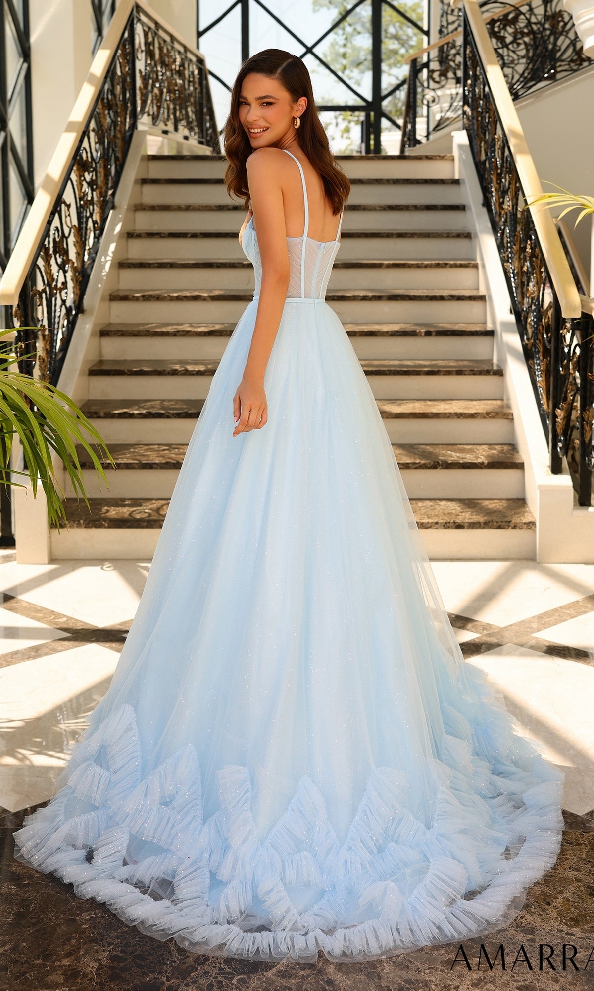 A woman in the Sheer-Corset Long A-Line Ruffled Prom Dress 88872 stands on a staircase, looking back over her shoulder.